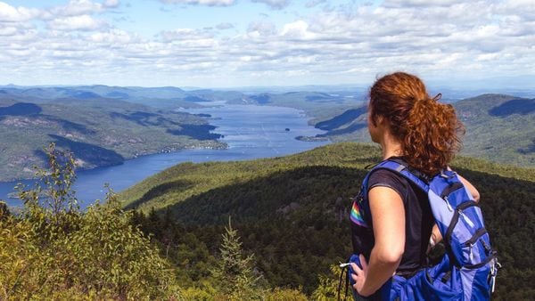 Female hiker taking in the view from Black Mountain Summit, overlooking Lake George in the Adirondacks